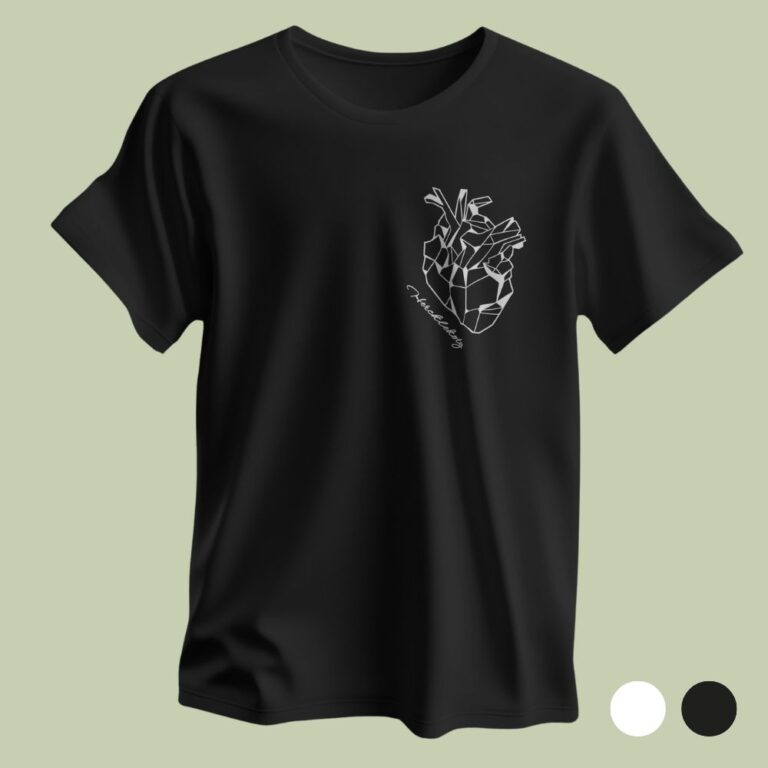 Zdjęcie typu flat lay przedstawiające czarny t-shirt rozłożony na jasnym, oliwkowym tle. Na koszulce, po lewej stronie, znajduje się nadruk geometrycznego, białego serca anatomicznego oraz napis „Hercklekoty” poniżej. W prawym dolnym rogu widoczne są dwa kółka: białe i czarne, oznaczające dostępne opcje kolorystyczne.