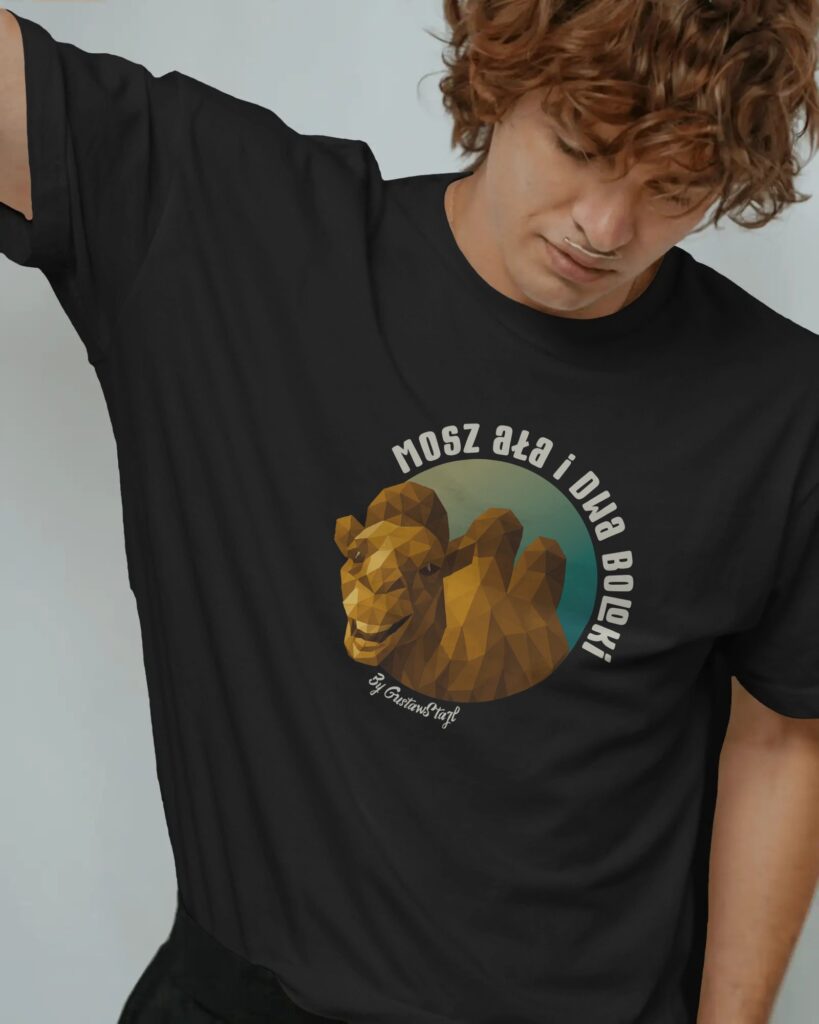 Młody mężczyzna o kręconych brązowych włosach, opierający się bokiem i patrzący w dół. Ma na sobie czarny T-shirt z nadrukiem przedstawiającym uśmiechniętego wielbłąda stworzonego z geometrycznych brył (low-poly) na tle turkusowo-złotego koła. Nad grafiką widnieje półkolisty napis: „MOSZ AŁA I DWA BOLOKI”, a pod nią mały napis „by GustawStajl”.